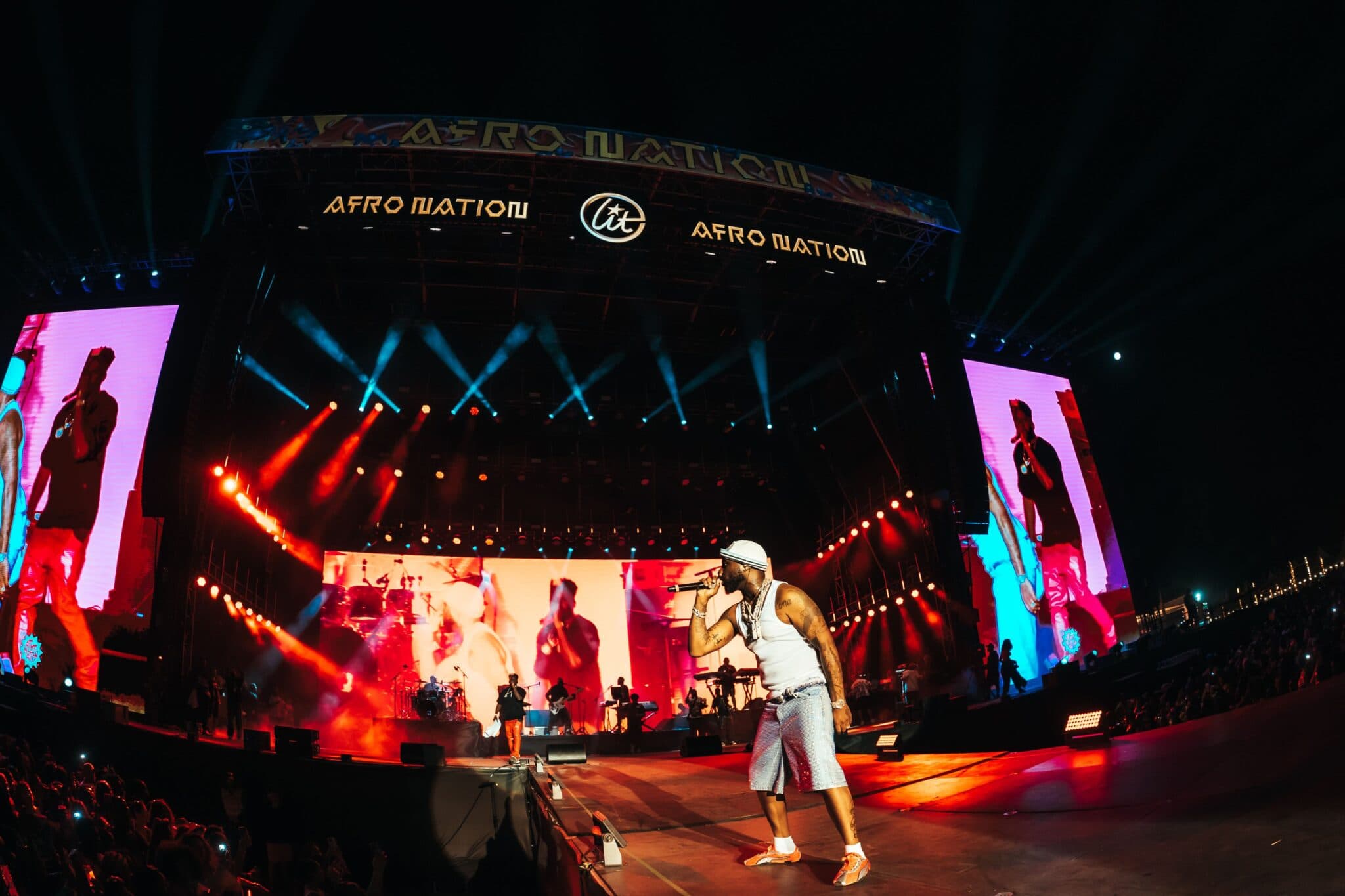 The Afro Nation main stage after dark, seen across the crowd