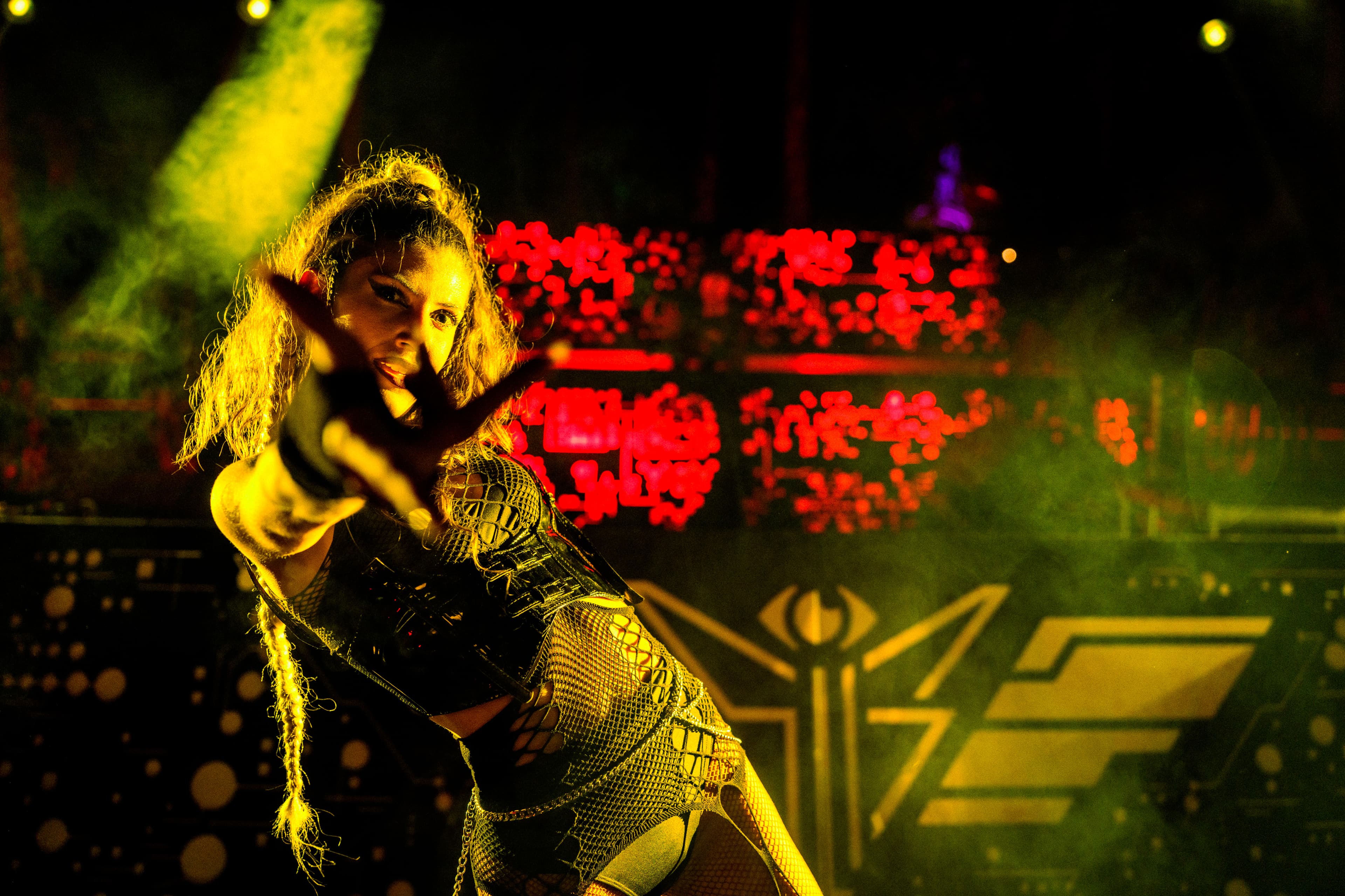 A performer on stage under yellow and red light.