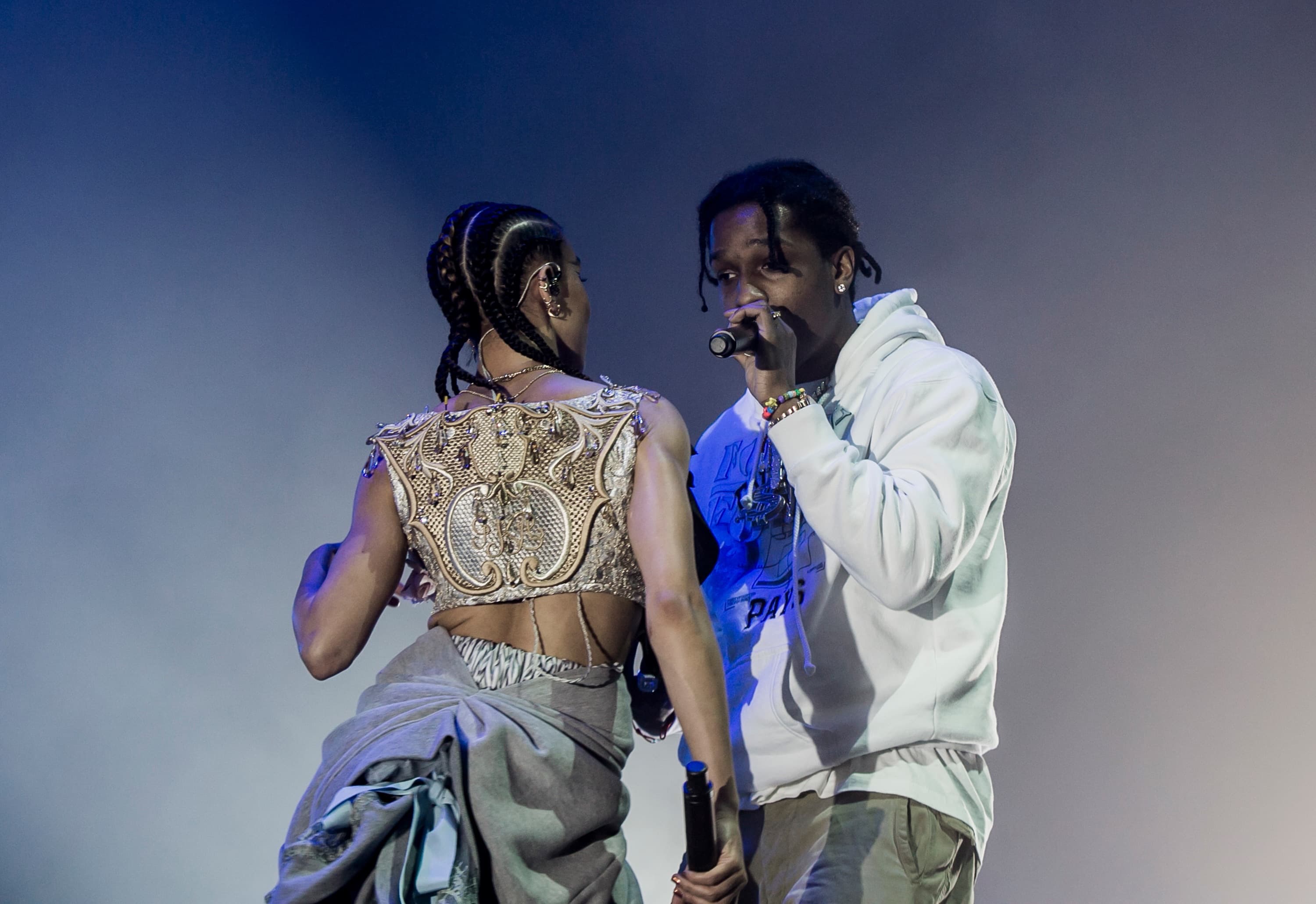 A$AP Rocky performing on stage with a second vocalist under blue light
